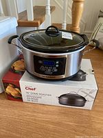 Front view of Hamilton Beach digital crockpot placed on top of the Master Chef roaster box showing both items together.