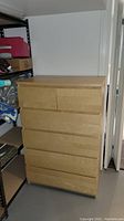 Front view of the wooden dresser showing 6 drawers, 4 full length and 2 half length on top, no handles on drawers