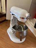 Angle view of white KitchenAid Professional HD stand mixer on wood floor