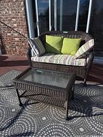 Loveseat and table on back porch showing overall condition and cushions