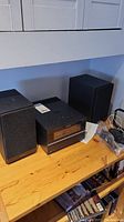 Sony micro hi-fi system unit with two black speakers placed on wooden surface