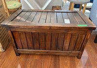 Closed solid wood storage chest, showing front panel with vertical slats and dark finish.