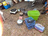 Full lot showing fishing rods, camping pots and pans, tackle box, propane stove and lantern.