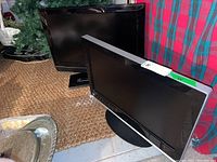 Two flat screen TVs shown, one labeled as 26 inch and the other 32 inch, positioned side by side on a surface.