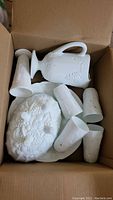Milk glass pitcher, glasses, vases, and oval dish in cardboard box