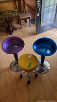 Set of three stools together, showing two colorful bucket stools and one yellow rolling stool.