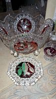 Footed candy dish showing birds etched on purple inset panels and decorative feet, along with accompanying coaster and mini vase.