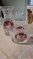 View of vintage lead crystal Hofbaur Byrds vase and matching dish with bird designs in red insets on tiled surface