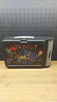 Front side of lunchbox showing Batman and Robin graphic with city skyline background.