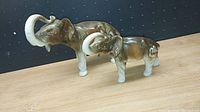 Photo showing two Royal Dux fine china elephant figurines, one larger and one smaller, both glazed brown and white