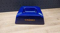 Front view of the blue square ashtray showing the gold 'CINZANO' branding on one side.