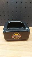 Front view of black ceramic ashtray showing colorful Double Diamond logo on side.