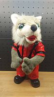 Front view of the plush wolf toy dressed in red Thriller jacket and red pants with black shoes.
