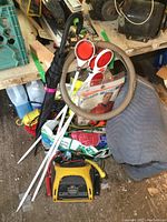 Overview showing yellow BDT jump starter, umbrella, moving blanket, reflectors, ropes, and other items in a pile.