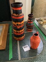 Three West German pottery vases arranged on slate tiles, showing the variety of sizes and colors