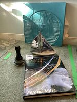 Photo showing all lot items: book, serving plate, sculpture, and compass