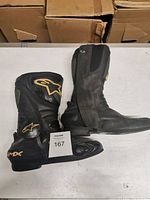Side view of the left and right black Alpine Star S-MX riding boots showing overall condition and size.