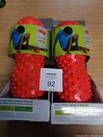 Two new red Gaiam Multi-Point Muscle Rollers in original packaging with instructional labels.