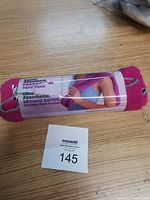 Photo of pink folded hand towel in packaging showing brand and product details.
