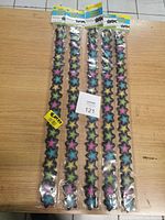 Five sealed packs of Magnetic Star Borders with colorful star patterns on wooden table.