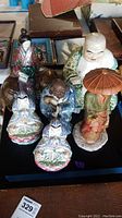 Overview of six hand painted vintage Asian porcelain figurines in multicolored glaze, arranged on table