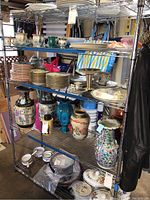 Full front view of the five-tier chrome metal shelving unit with items on shelves for context but not included in sale.