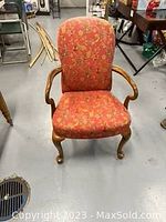 Front view of the Queen Anne style chair showing wood frame, floral upholstery, and cabriole legs.