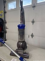 Dyson Ball Allergy vacuum cleaner standing on table, showing ball design and clear dust bin