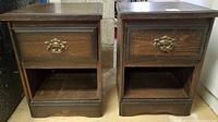 Pair of matching vintage wood night tables side by side showing front with drawers and open shelves.