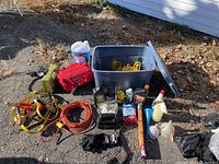 Full view of car care and emergency supplies including bin, jumper cables, extension cords, fluids, gloves, and tool kits.