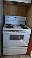 Front view of white freestanding range with coil burners and control panel