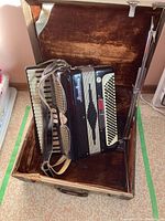 Accordion and stand inside open brown lined case