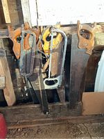 Photo showing the full collection of 6 hand saws arranged against a rough wooden backdrop, consisting of 4 traditional wood saws and 2 metal coping saws.