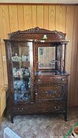 Full view of the vintage wooden display cabinet with side by side arrangement of the glass china cabinet and mirror with storage.