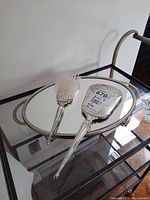 Wide shot showing the Birks Regency silver plated plate brush and mirror on a mirrored tray.