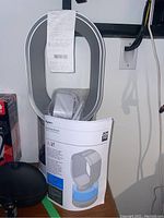 Overall view of Dyson humidifier AM10 with instruction manual and sales receipt attached at top