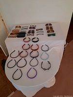 Full view of hair hoop headbands, sunglasses, glasses, and cases arranged on a white table