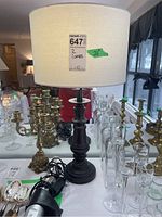 Photo of lamp with metal base and cream fabric shade, showing 26 inch height label and surrounding glassware and candlesticks.