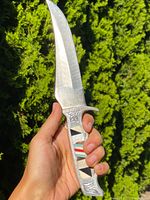 Full view of knife held in hand, showing blade profile and handle size