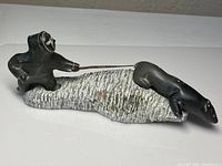 Full view of the sculpture showing the Inuit hunter with spear and polar bear on a textured base.