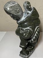 Photo showing the full figure of the soapstone sculpture, including mother carrying child and detailed carving.