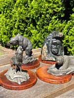 Group shot of all four sculptures on outdoor wooden surface