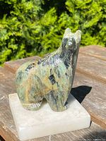 Front view of soapstone bear sculpture on marble base