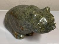 Angled front view showing overall shape, detailing, and polished greenish soapstone material.