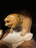 Front and side views of the soapstone bear bust sculpture showing detailed carving and natural coloration.