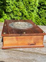 Side view of the cedar wood box highlighting the wood grain and condition of the sides.