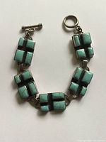 Top view of the bracelet showing the turquoise stones set in five rectangular silver panels with toggle clasp visible.