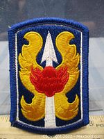 Clear close-up of 199th Brigade embroidered military patch on blue fabric background with yellow and red thread details.