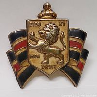 Front view of the antique British War Relief pin with the crowned lion emblem and enamel stripes.