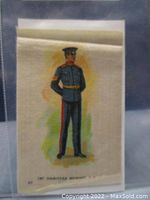 Photo of a small antique tobacco silk showing a soldier in detailed blue military uniform printed on fabric.